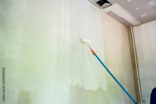 Obraz na plátně Painting wall roller renovation white interior construction home repair ceiling