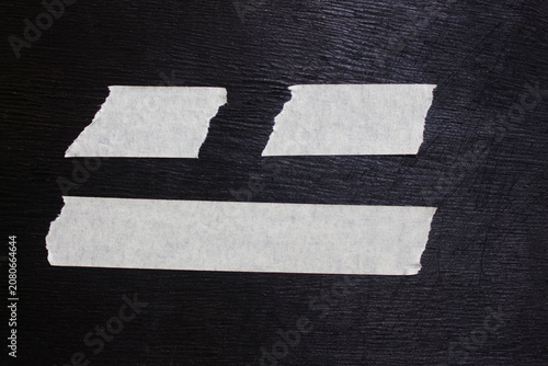 Paper plaster with some cuts on black background
