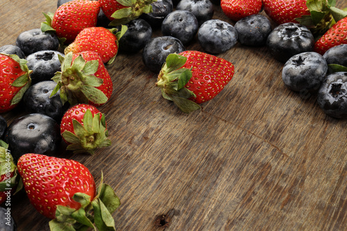 Fresh ripe Blueberry strawberry grape macro closeup on wood dark white background