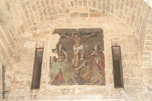 Canvastavla Faded medieval fresco of the Crucifixion inside an ancient stone archway in Mono