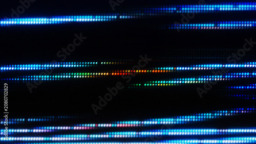 Fotografie Abstract digital background with horizontal rows of glowing blue and rainbow LED pixel lights on a dark screen