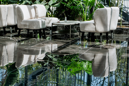 Valokuva Polished black marble flooring with mirror-like reflections of ivory boucle tub