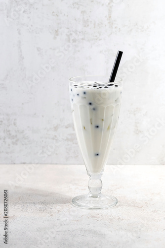 A glass of milkshake with ice and bubble boba tapioca