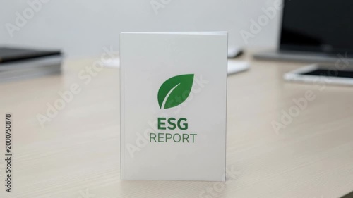ESG report with green leaf symbol on white cover representing environmental social governance concept