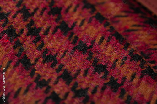 Close-Up Houndstooth Wool Fabric Texture in Red, Orange and Black Tones