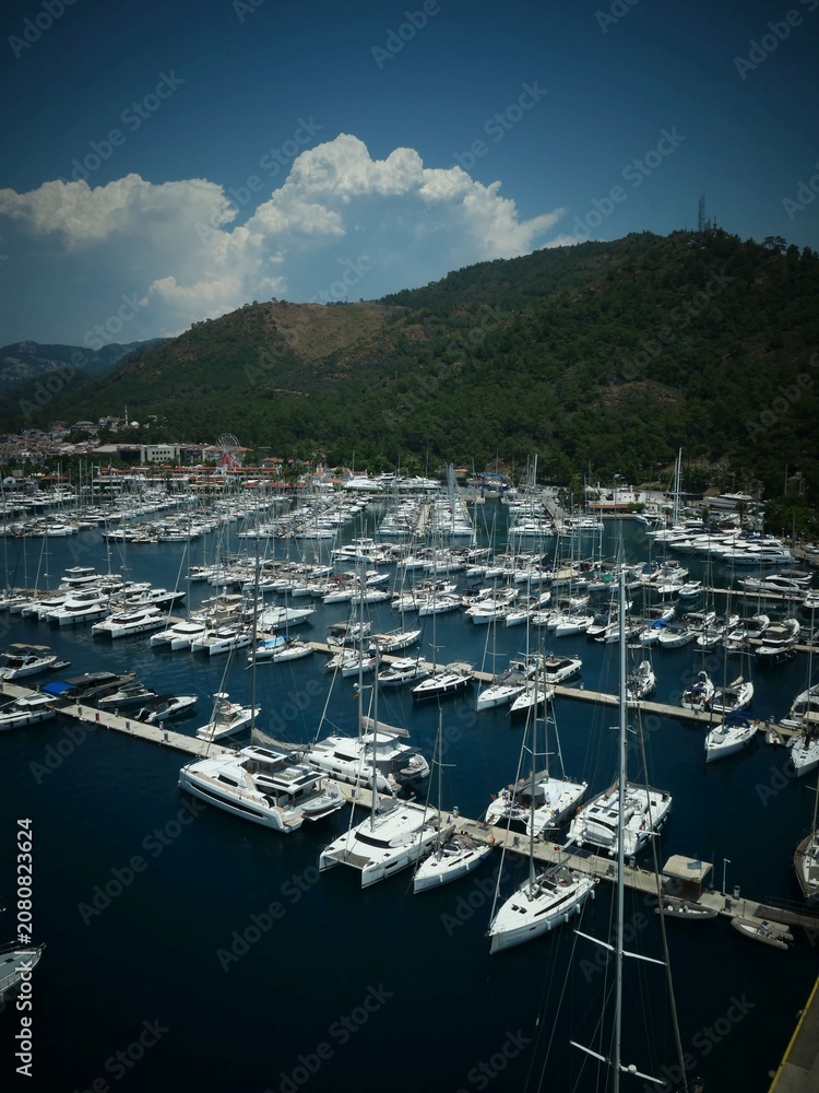 Fototapeta premium Aerial view of white yachts docked at a coastal marina
