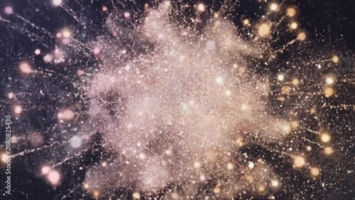 Abstract background featuring a bright golden explosion of light particles and glitter.