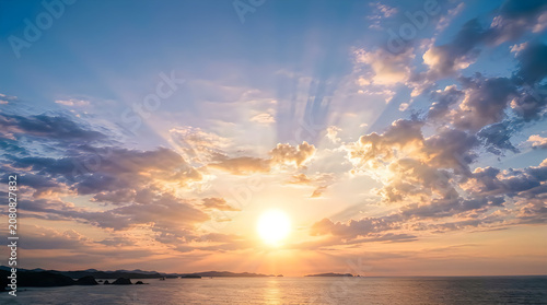 Dramatic sunset over ocean with natural cloud formations and golden sunlight