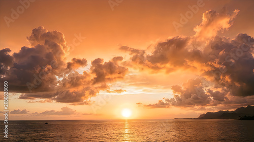 Golden sunset over ocean with dramatic natural cloud formations