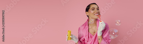 Εκτύπωση καμβά Charming young woman brings joy and style with bubbles against a pink backdrop