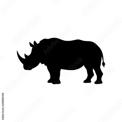 A black silhouette of a rhinoceros stands alone in a savannah landscape