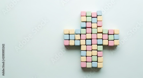 Colorful sugar cubes forming a cross shape on a light blue background