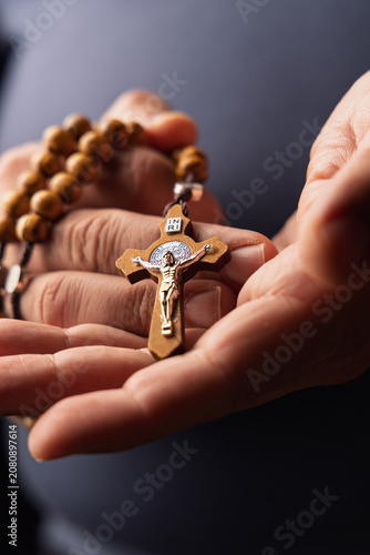 Fotografie Hands of a person with a wooden rosary for representing religious prayer and christian faith and spirituality during holy friday
