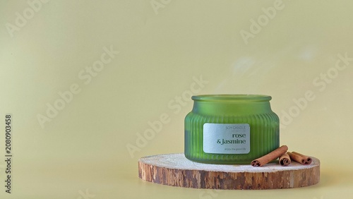 Photos A freshly extinguished scented candle in a green ribbed jar with a trail of white smoke rising from the wick