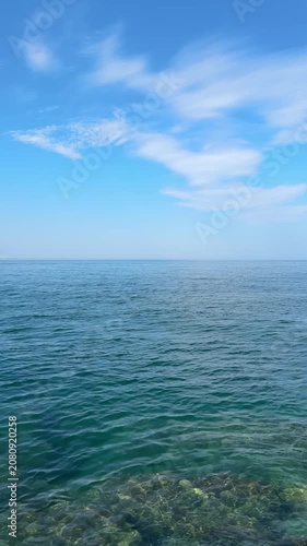 Open blue sea and sky clouds horizon, vertical video.