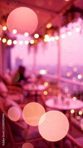 A Cozy Evening Ambiance: Warm Bokeh Lights and Soft Pink Hues Brighten a Serene Outdoor Cafe Setting, Inviting Relaxation and Capturing Memories with Friends