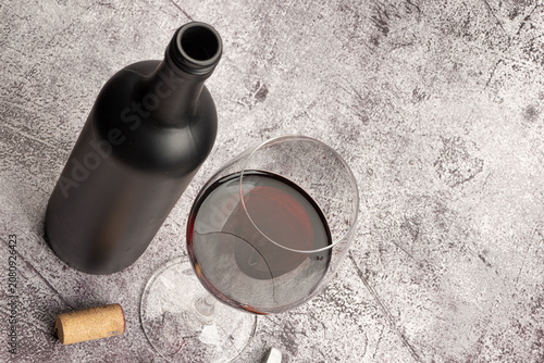 red wine served in a crystal glass with a bottle beside it and corkscrew