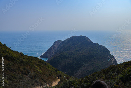 Scenic coastal hiking trail above rugged headland and blue ocean
