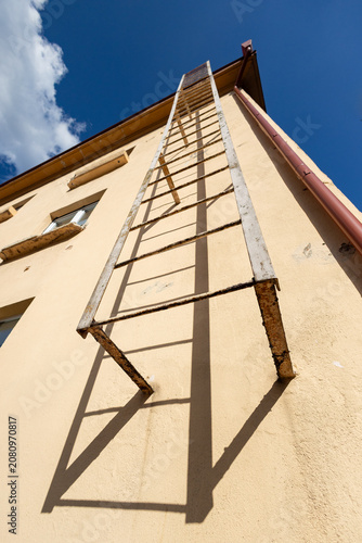 Low Angle View of Rusty Fire Escape Ladder on Building Exterior