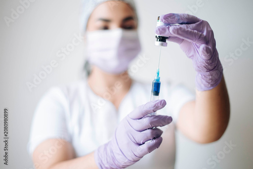 Tableau sur toile Healthcare professional preparing injectable medication from a vial using sterile technique before patient treatment