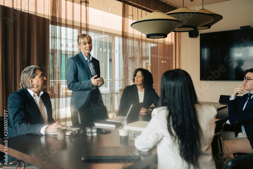 Female business executive pitching sales strategies to corporate partners during meeting in office