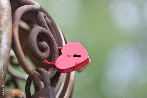 Obraz na płótnie Pink heart shaped  love padlock locked on a bridge metal fence, romance concept