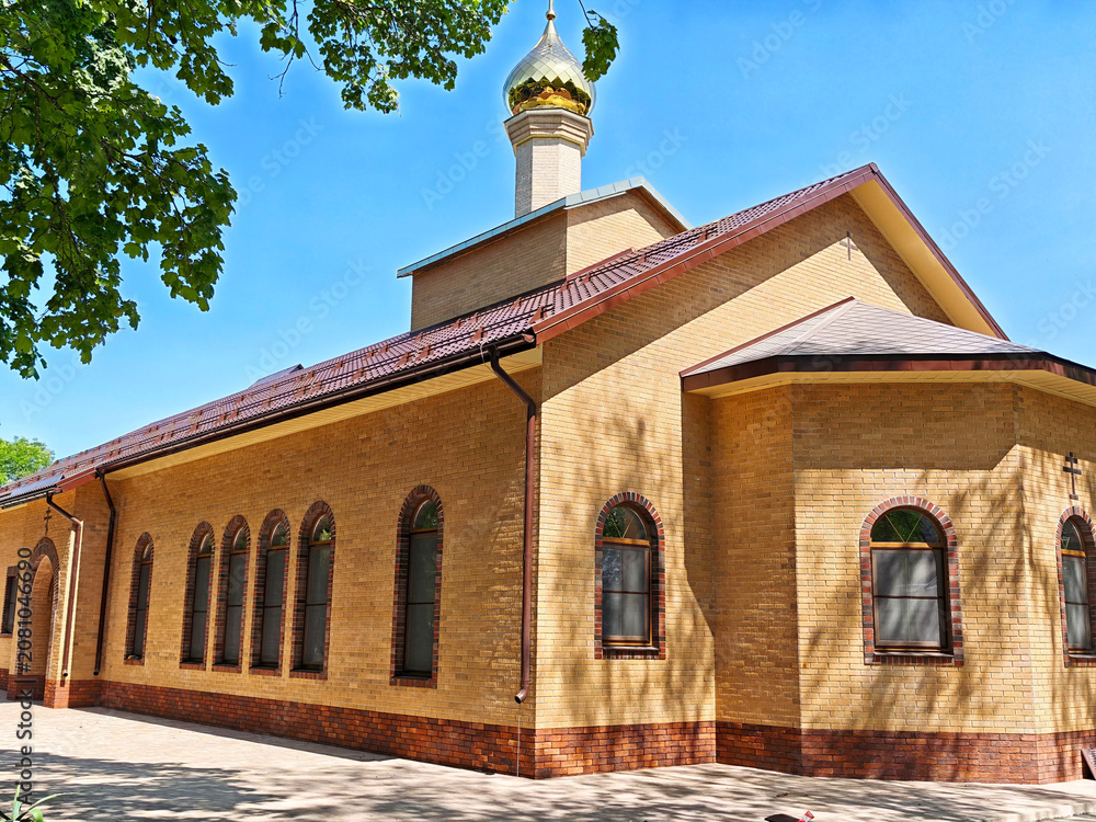 Fototapeta premium St. Michael's Athos Monastery located in Adygea, Russia, showcases its architectural design and structure under the bright sky in a peaceful setting during daylight hours