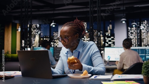 Cuadro en lienzo Stressed businesswoman dealing with eating disorder during late night work session, temptation