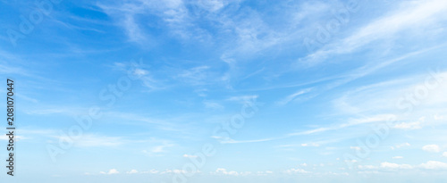 Beautiful clear blue sky background with soft white clouds and empty copy space for panoramic summer travel mockup design
