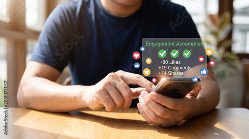 A person uses a smartphone to view digital social media engagement metrics featuring colorful icons and checkmarks in a bright and high quality close up shot