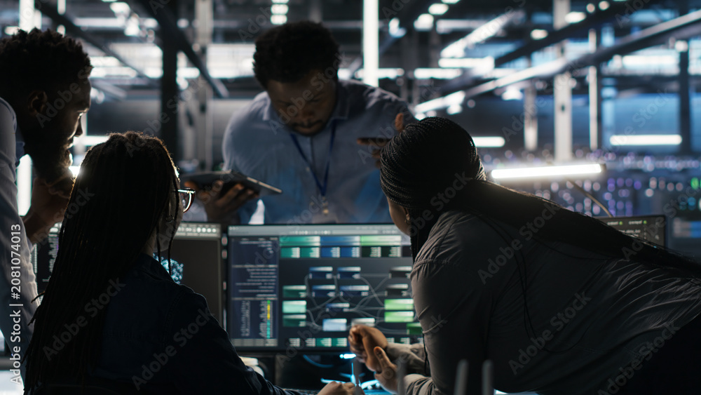 Fototapeta premium Data center colleagues use node tree software together to analyze datasets and optimize system health.