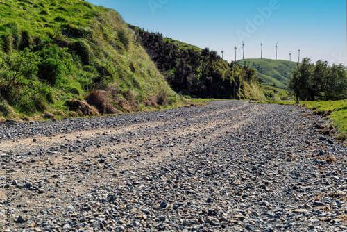 Foto Car background, automotive backplate, gravel country road with wind turbines in