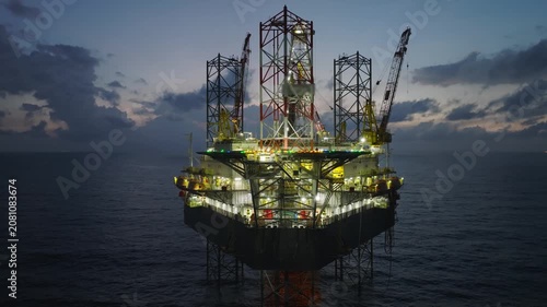 Aerial view of offshore jack up rig and offshore platform during sunset for oil and gas exploration and production. 