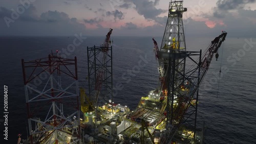 Aerial view of offshore jack up rig and offshore platform during sunset for oil and gas exploration and production. 