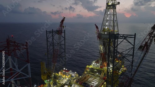 Aerial view of offshore jack up rig and offshore platform during sunset for oil and gas exploration and production. 