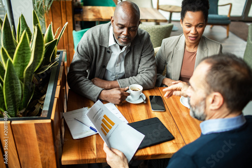 Mature couple meeting financial advisor in cafe
