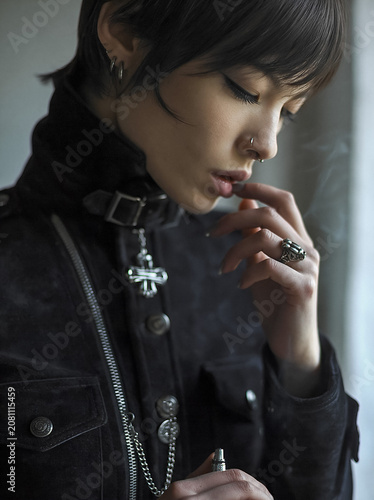 Portrait of an Androgynous Model in Gothic Fashion Featuring Intricate Silver Jewelry and Dark Edgy Apparel
