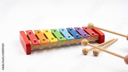 Child's colorful wooden xylophone with mallets being played