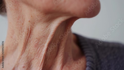 Close-up of the neck and chest of an older person, showing skin texture and wrinkles