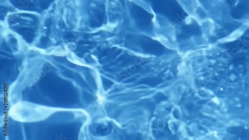 Abstract close-up of flowing water, with light reflecting and creating a textured surface
