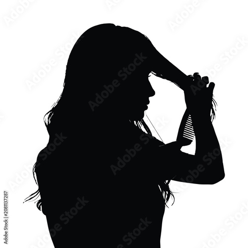 Silhouette of a young woman brushing her long dark hair