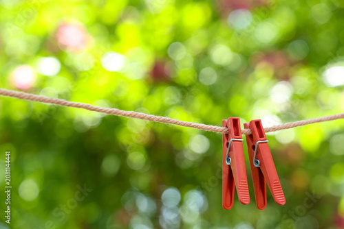Foto Two red clothespins on a clothesline with green bokeh background