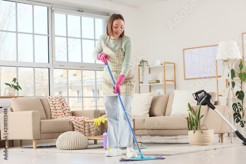 Young woman mopping floor i...