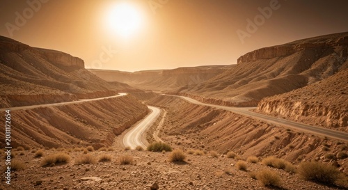 Desert canyon highway winds through sunlit, arid terrain, under a bright sky