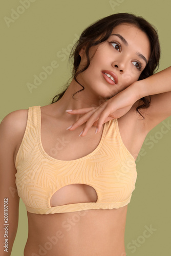 Sexy young woman in swimsuit on green background