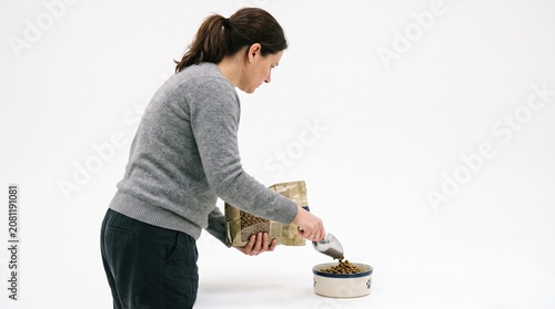 Photorealistic side profile of person without face, filling pet food bowl, gentle chore, pure white isolated setting