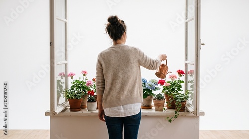 Photorealistic person from behind, no face, watering flowers on windowsill, soft lighting, pure white studio background
