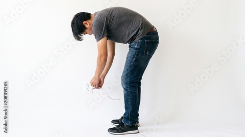 Photorealistic side view person, no face, plugging charger into wall outlet, everyday chore, isolated white background
