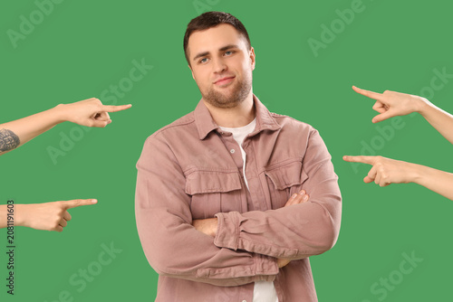 Fotografie People pointing at young man on green background