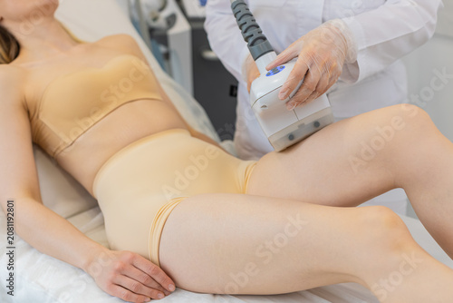 Quadro su tela Cosmetologist doctor makes to young adult woman cavitation LPG vacuum roller massage on legs
